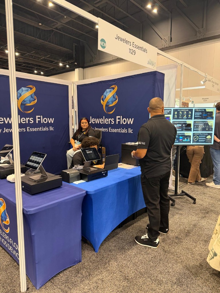 Jewelers Flow booth 1129 with a visitor reading the six core pillars display